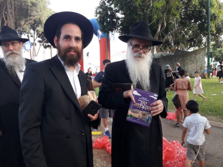 הרב הלפרין עם ספרון התהלוכה
