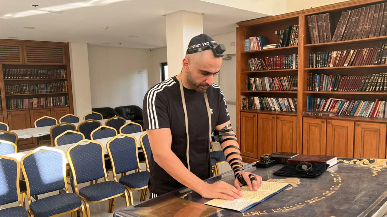 יהודים מניחים תפילין בבית הכנסת של בית חב"ד